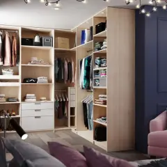 Aménagement de dressing moderne avec étagères, penderies et tiroirs en bois clair.