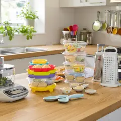 Robot culinaire, râpe et contenants colorés, des outils indispensables en cuisine pour préparer de délicieux repas.
