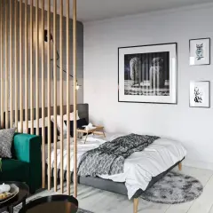 Chambre moderne séparée par un paravent en bois, avec un canapé vert et un lit.