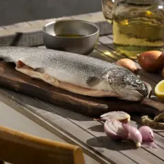 Poisson cru sur planche, citron, oignons et huile. Idéal pour enlever l'odeur de poisson maison.