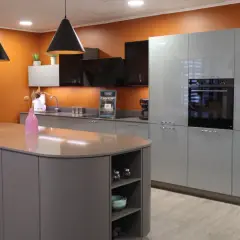 Cuisine moderne avec îlot central gris et meubles muraux bleus. Le vide sanitaire derrière le meuble cuisine est discret.