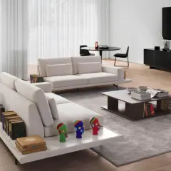 Un salon moderne avec un canapé face à face et une TV. Des livres décorent les accoudoirs et une table basse.