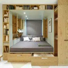 Lit intégré avec rangements et étagères en bois, décoré de coussins.