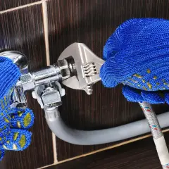 Mains pour brancher machine à laver sur robinet classique avec une clé.