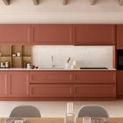 Cuisine moderne avec des armoires couleur terre cuite, un évier, un four et des chaises grises.