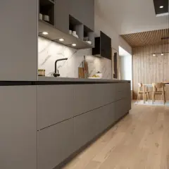 Cuisine moderne et épurée, une cuisine sans poignée aux lignes nettes. Le plan de travail en marbre contraste avec les façades grises.