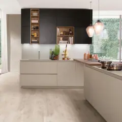 Cuisine moderne avec îlot central, armoires noires et bois, et grande fenêtre végétalisée.