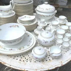 Vaste service de porcelaine à la cendre d'os, orné de délicates fleurs, comprenant théière, tasses, bols et assiettes.