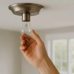 Main tenant change une ampoule classique car le plafonnier LED ne fonctionne plus.