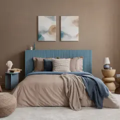 Une peinture chambre adulte 2 couleurs, avec un lit douillet, un fauteuil en rotin et des tableaux abstraits.