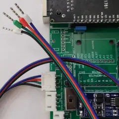 Fils multicolores, dont un fil noir et blanc 12V, connectés à une carte électronique.