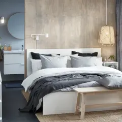 Chambre parentale moderne avec lit, coiffeuse, lavabo et miroir.