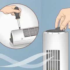 Démontez le ventilateur colonne avec un tournevis pour le nettoyer. Une main tourne le bouton de réglage.