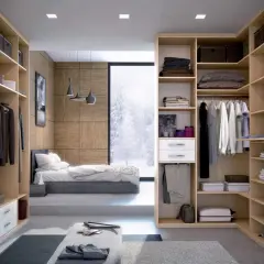 Un dressing fermé bien organisé, avec des étagères en bois clair, des vêtements suspendus et pliés, et une vue sur un paysage hivernal.