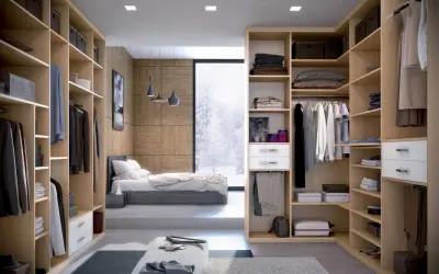 Un dressing fermé bien organisé, avec des étagères en bois clair, des vêtements suspendus et pliés, et une vue sur un paysage hivernal.
