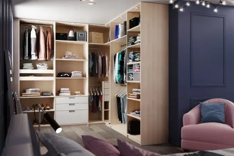 Aménagement de dressing moderne avec étagères, penderies et tiroirs en bois clair.