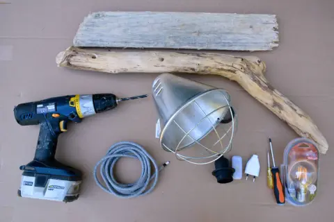 Matériel pour fabriquer une lampe en bois flotté : bois, perceuse, douille, câble, abat-jour, ampoule LED et tournevis.