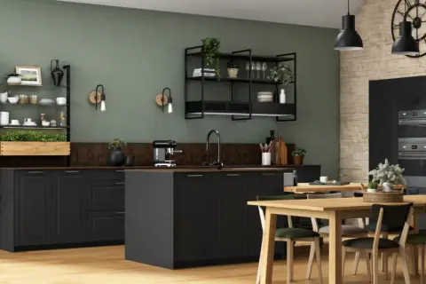 Cuisine style bistrot avec étagères métalliques, plantes vertes, îlot central noir et table en bois.