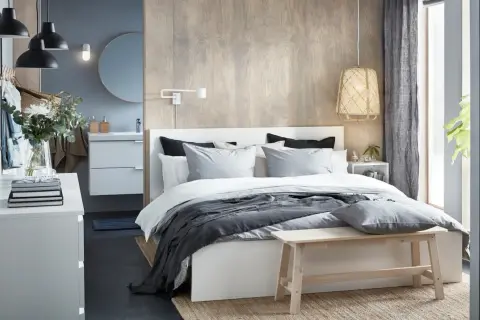 Chambre parentale moderne avec lit, coiffeuse, lavabo et miroir.