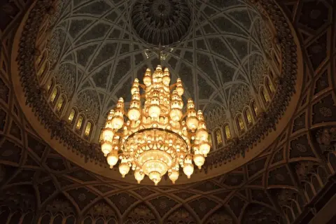 Majestueux lustre en bronze illuminant un dôme orné. Comment estimer un lustre en bronze de cette ampleur ?