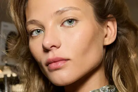 Un visage de femme aux yeux verts, peau lumineuse. Comment reconnaître du bronze ? La peau de ce modèle a un éclat naturel, comme si elle était hâlée par le soleil.