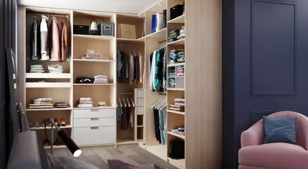 Aménagement de dressing moderne avec étagères, penderies et tiroirs en bois clair.