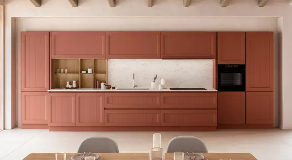 Cuisine moderne avec des armoires couleur terre cuite, un évier, un four et des chaises grises.