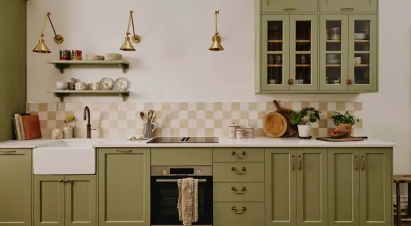 Cuisine vert d'eau avec évier, plaque de cuisson, four et placards en bois.