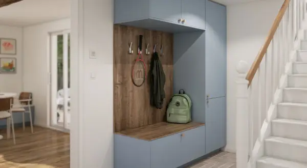 Aménagement placard entrée bleu pastel avec banc, patères pour manteaux et raquette, et sac à dos vert. Un escalier blanc est visible à droite.