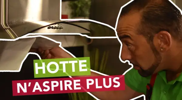 Un homme examine sa hotte neuve qui n'aspire pas. Il vérifie le filtre, cherchant la cause du problème.