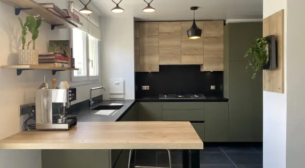 Cuisine moderne avec meubles vert olive, bois clair et plan de travail noir.