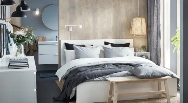 Chambre parentale moderne avec lit, coiffeuse, lavabo et miroir.
