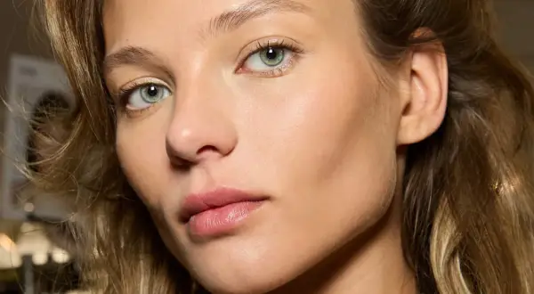 Un visage de femme aux yeux verts, peau lumineuse. Comment reconnaître du bronze ? La peau de ce modèle a un éclat naturel, comme si elle était hâlée par le soleil.