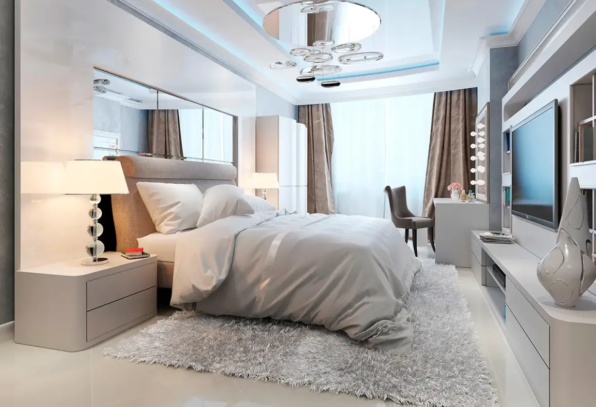 Chambre moderne avec un grand lit douillet, un miroir au dessus du lit reflétant le plafond design et une télévision murale.