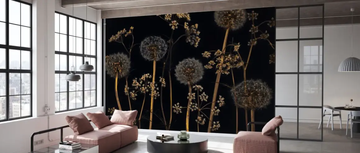 Pissenlits et herbes folles sur fond noir, aux reflets couleur laiton, dans un loft moderne.