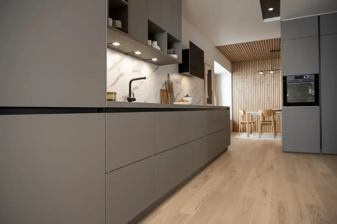 Cuisine moderne et épurée, une cuisine sans poignée aux lignes nettes. Le plan de travail en marbre contraste avec les façades grises.