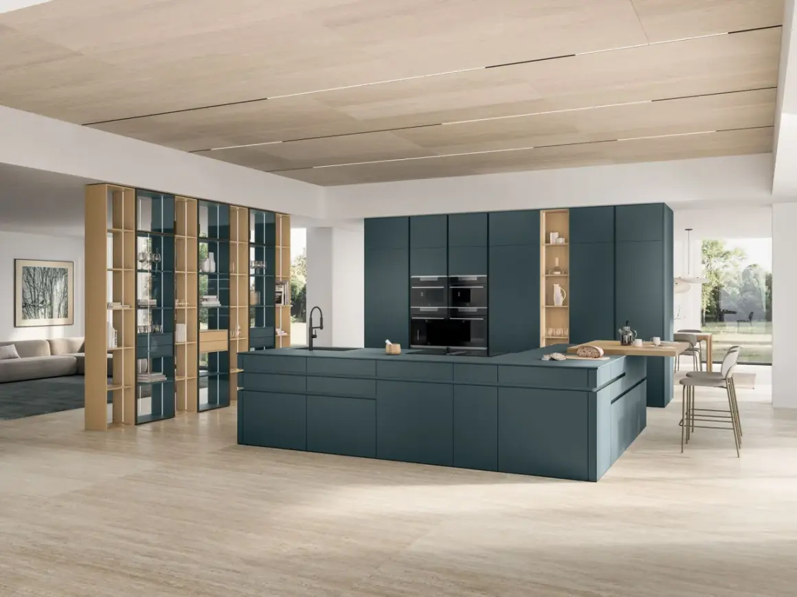 Cuisine moderne avec îlot central bleu canard, armoires intégrées et étagères en bois.