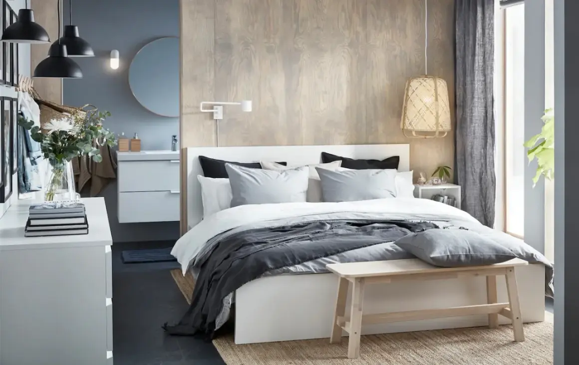 Chambre parentale moderne avec lit, coiffeuse, lavabo et miroir.