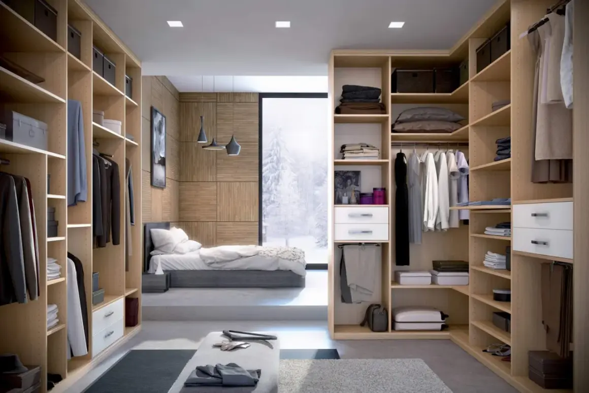 Un dressing fermé bien organisé, avec des étagères en bois clair, des vêtements suspendus et pliés, et une vue sur un paysage hivernal.