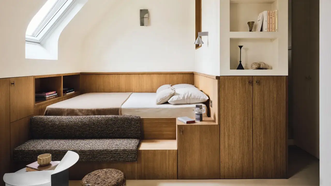 Ambiance cosy dans cette chambre parentale aux tons boisés, avec un lit intégré, des rangements astucieux et une banquette confortable.