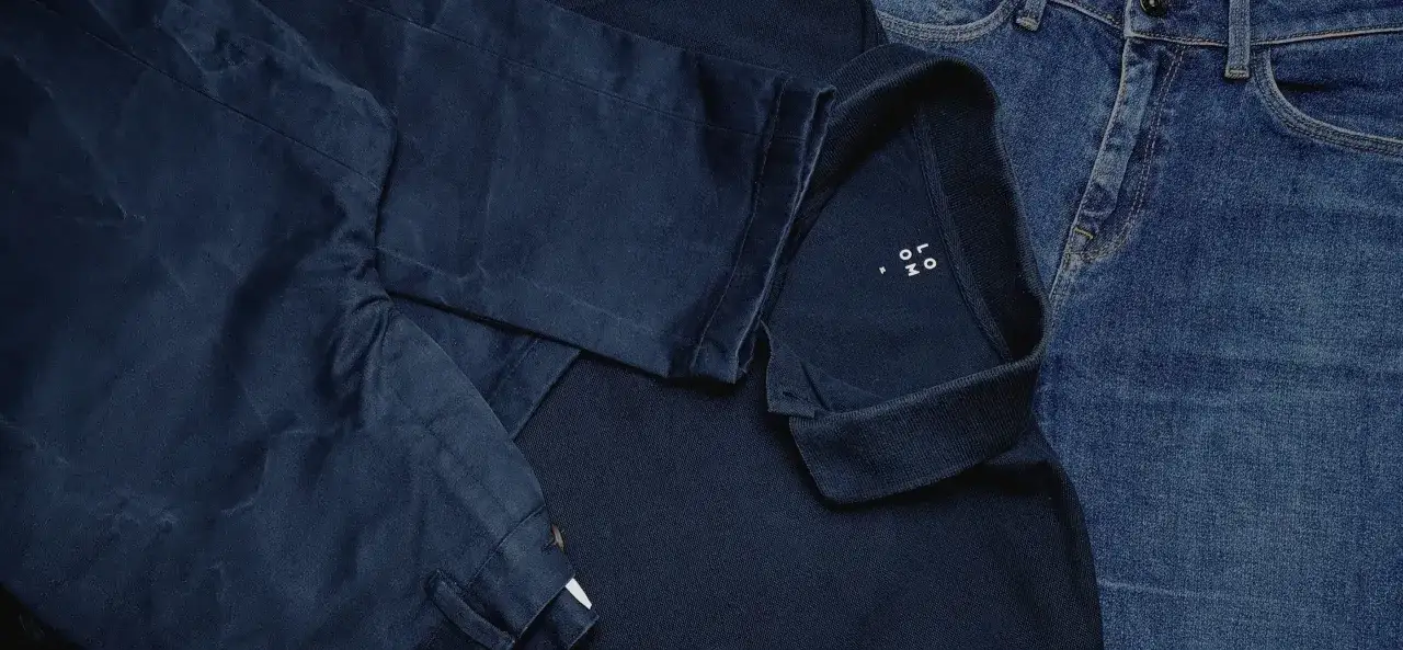 V&ecirc;tements bleus, dont un polo et un jean, avec des marques sugg&eacute;rant comment enlever des taches de d&eacute;coloration.