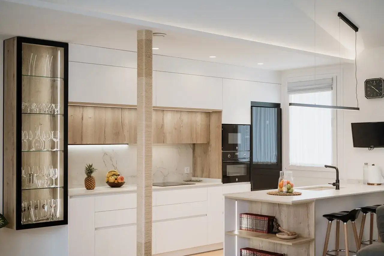 Cuisine moderne et &eacute;pur&eacute;e, une cuisine sans poign&eacute;e aux finitions bois et blanc, avec une vitrine lumineuse et des appareils int&eacute;gr&eacute;s.