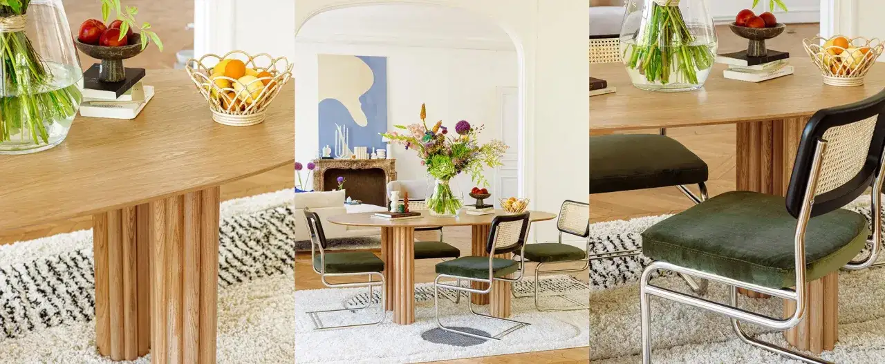 Table en bois au design lent, chaises vertes et rotin, tapis moelleux. Ambiance chaleureuse et naturelle.