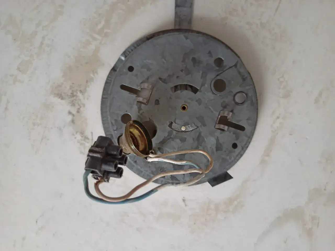 Base m&eacute;tallique de plafonnier avec douille et fils d&eacute;nud&eacute;s, pr&ecirc;te pour d&eacute;monter un globe.