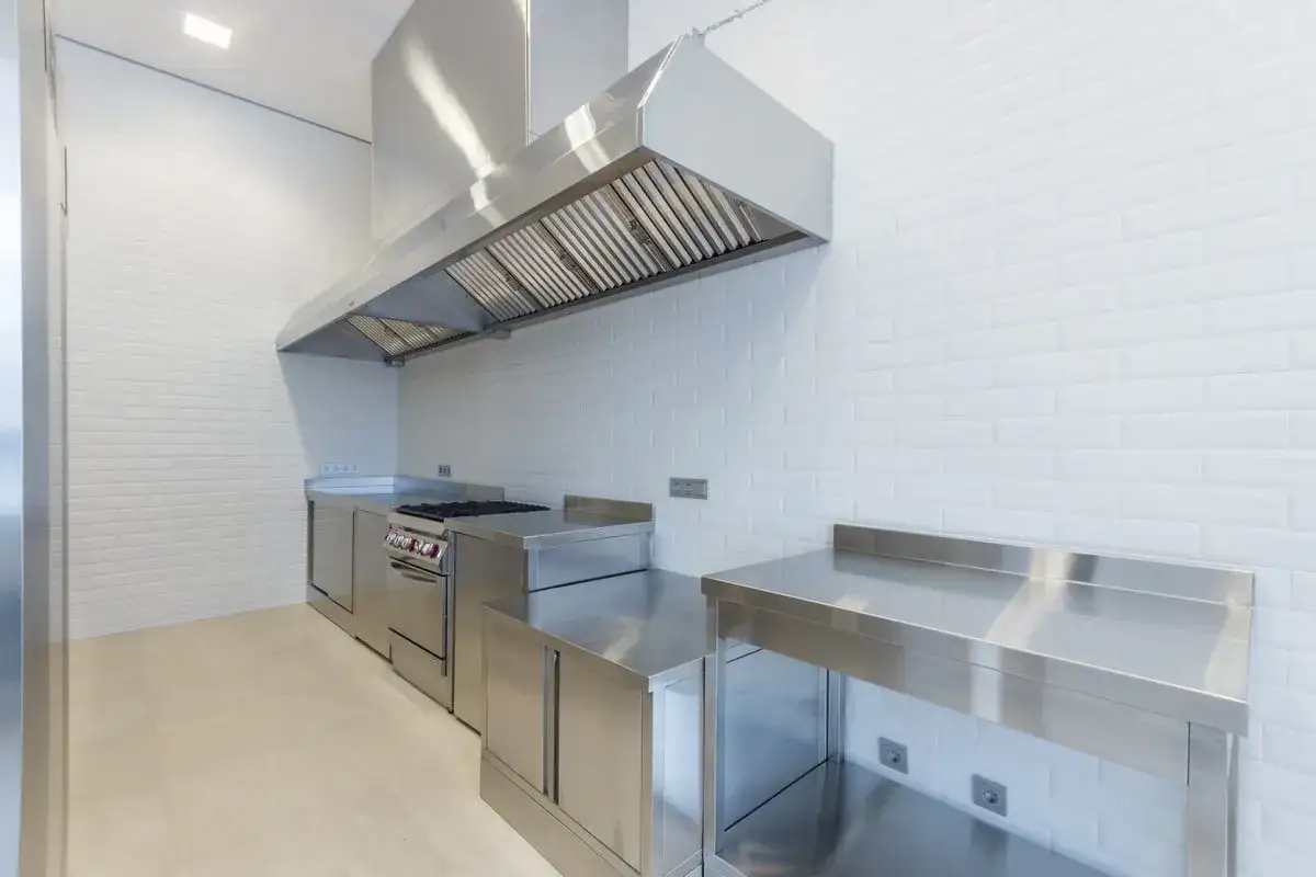 Cuisine professionnelle avec hotte en inox, cuisinière et plans de travail. Je me demande pourquoi ma hotte neuve n'aspire pas.