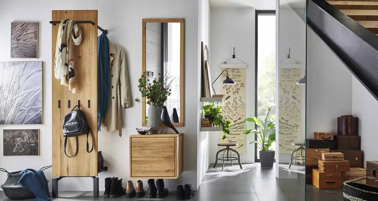 Idée pour aménager une entrée couloir : porte-manteaux en bois, miroir, rangements et décoration murale.