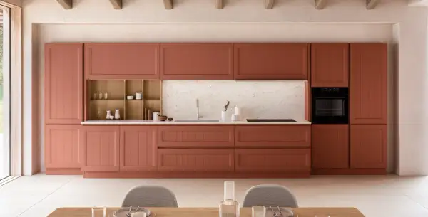 Cuisine moderne avec des armoires couleur terre cuite, un évier, un four et des chaises grises.