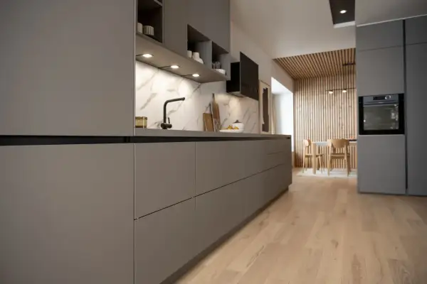 Cuisine moderne et épurée, une cuisine sans poignée aux lignes nettes. Le plan de travail en marbre contraste avec les façades grises.