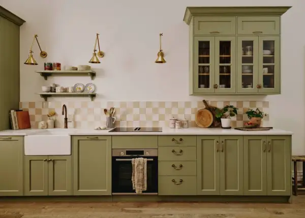 Cuisine vert d'eau avec évier, plaque de cuisson, four et placards en bois.