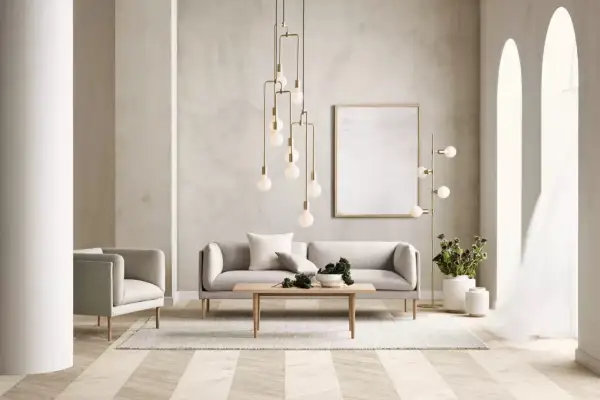 Salon moderne avec canapé gris, fauteuil, table basse en bois et un lustre spectaculaire en laiton matiere.